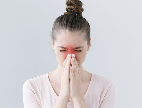 Chảy dịch mũi sau do viêm xoang có thể gây khàn tiếng và đau họng